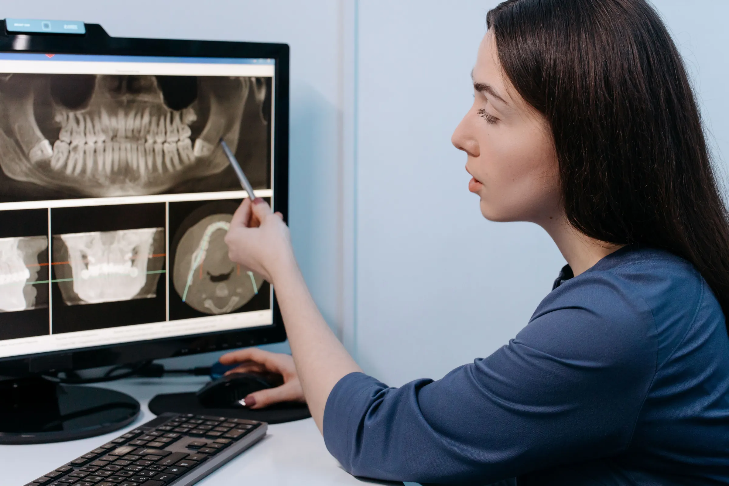 A clinician reviews a panoramic dental X-ray on a monitor